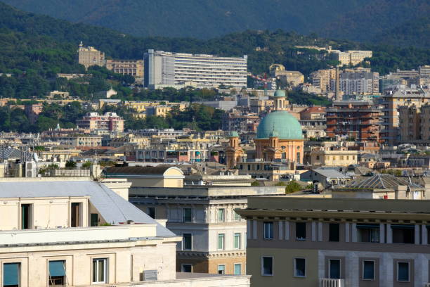 View of Genoa's rooftops at sunset, showcasing the city's historic skyline and warm golden light.