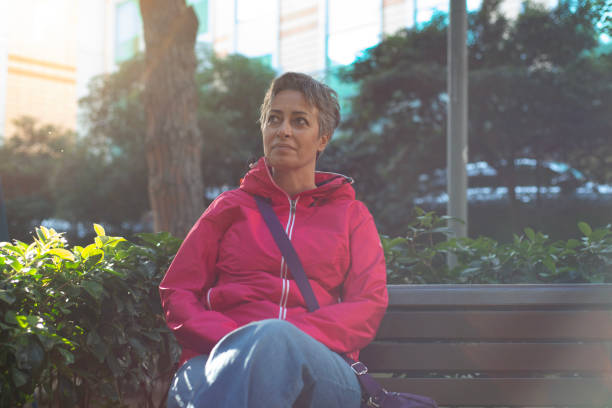 istock Middle aged woman posing in a public park 2182329077