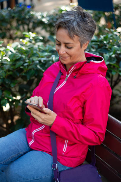 istock Senior woman using mobile phone in park. 2182329363