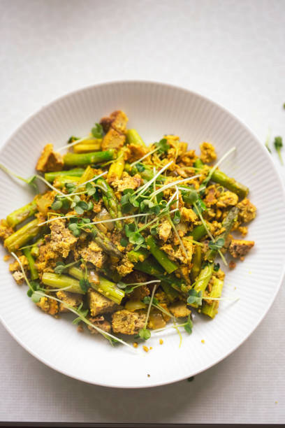 Scrambled tofu with green asparagus, spinach and micro greens