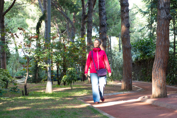istock Woman walking in a road with trees 2182330197