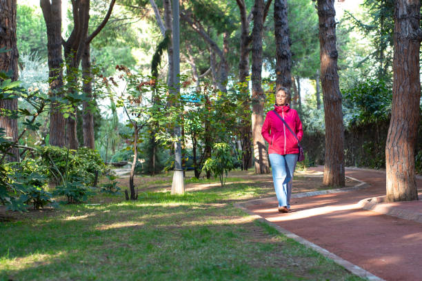 istock Woman walking in a road with trees 2182330337