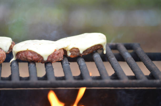 Hamburgers on outdoors grill over a fire