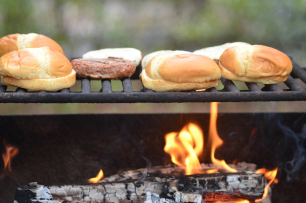 Hamburgers and buns on outside grill over open fire