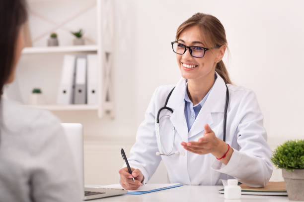 istock Smiling Doctor Woman Talking With Unrecognizable Patient Sitting In Office 2182333016