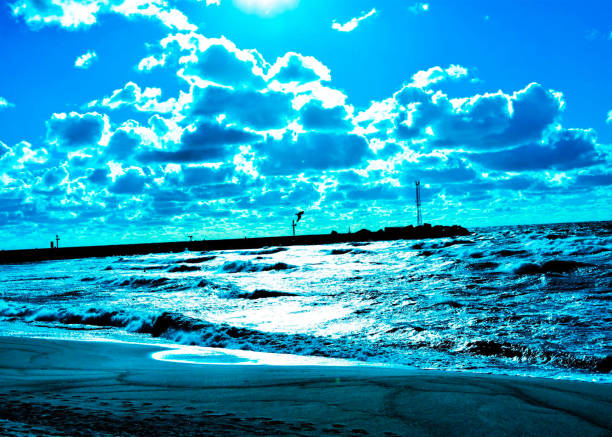 A beautiful, expansive blue sky dotted with fluffy clouds is gracefully reflected over a tranquil body of water beneath it