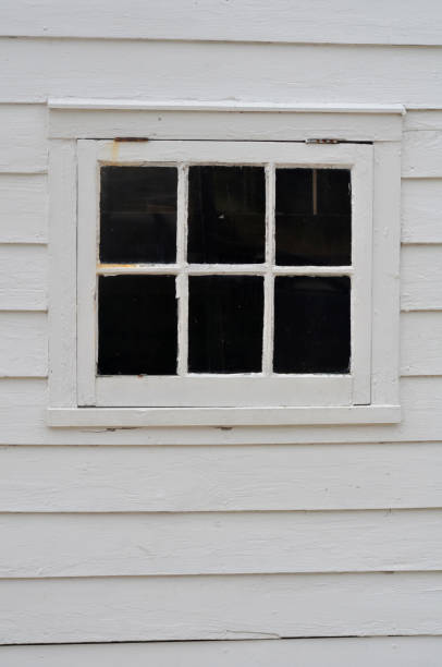 istock Small antique window with white wooden siding 2182337043