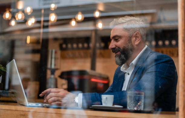 istock A happy mature business man using his laptop at a restaurant cafe. 2182345856