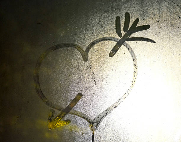a heart pierced by an arrow drawn on glass. expression of sympathy, declaration of love, loyalty and friendship. expression of feelings by means of a drawing
