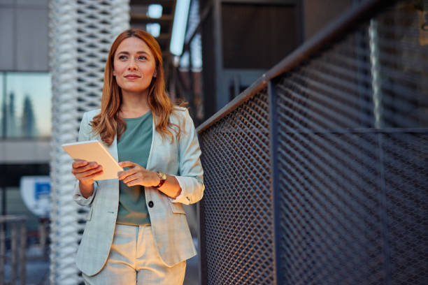 istock Business lady happily walking with digital tablet outside 2182358846