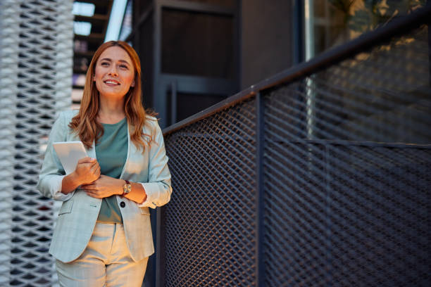 istock Business lady happily walking with digital tablet outside 2182358854
