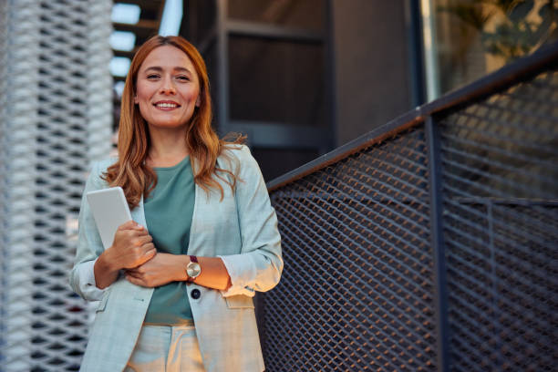 istock Business lady happily walking with digital tablet outside 2182358857
