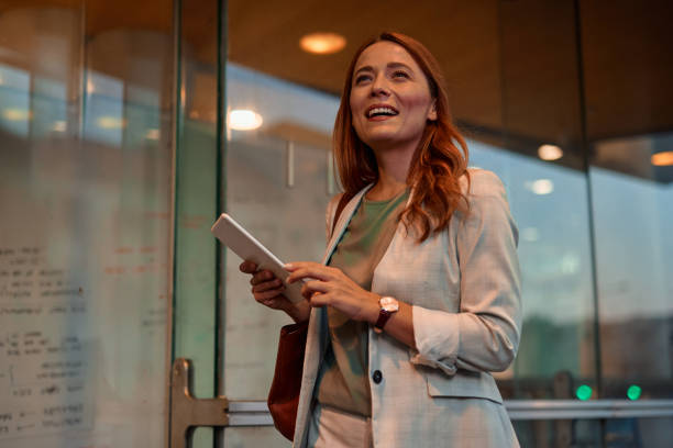 istock Confident Businesswoman Walking with Tablet in Urban Setting 2182358892