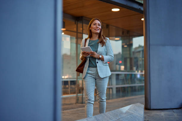 istock Confident Businesswoman Walking with Tablet in Urban Setting 2182358893