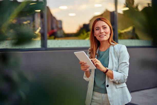 istock Businesswoman Using Tablet In Front Of The Office Building 2182359072