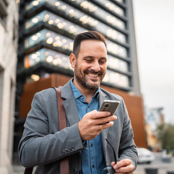 istock man businessman stand in front modern building and use mobile phone 2182360992