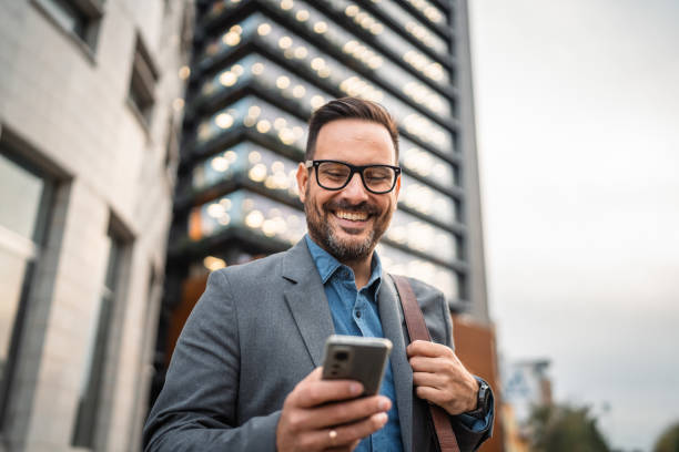 istock man businessman stand in front modern building and use mobile phone 2182361281