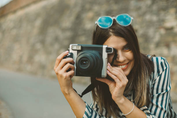 istock Young woman with an instant camera 2182364572