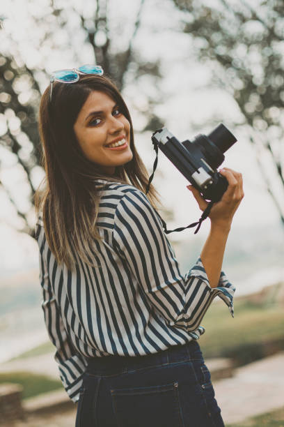 istock Young woman with an instant camera 2182364627
