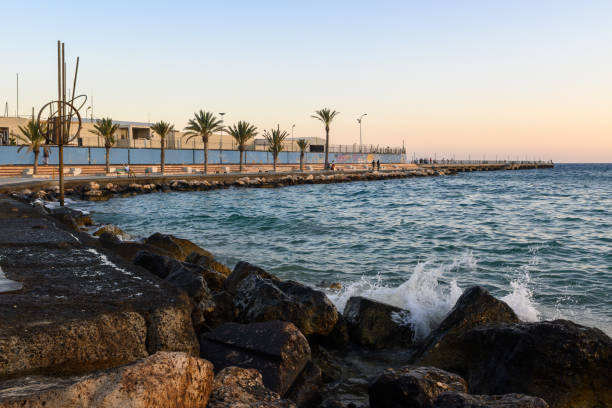istock A serene coastal promenade lined with palm trees at sunset, inviting relaxation and contemplation by the sea 2182367789