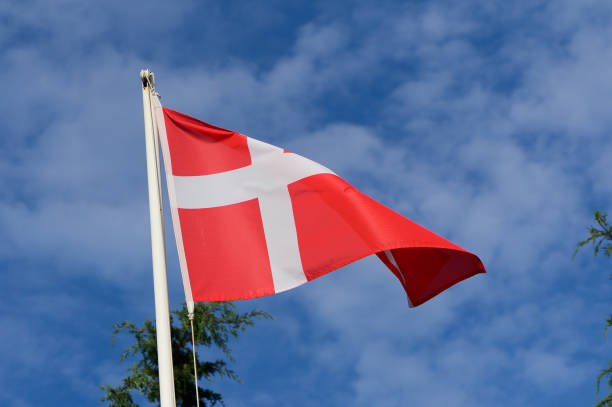 istock A vibrant Danish flag waves gracefully against a backdrop of blue sky and fluffy clouds 2182367799
