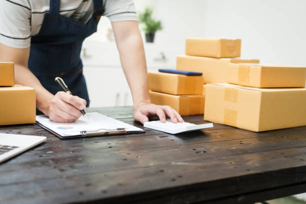 istock A man is working at his desk, preparing parcel boxes for shipment. He checks and packs items carefully, using shockproof materials, and attaches labels before sending them to customers via EMS. 2182393354
