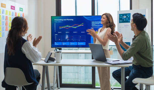 istock group of investor celebrating a successful outcome in a modern office clapping hand  in front of a digital screen displaying financial data 2182396814