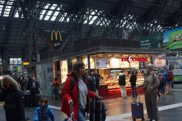 The expansive concourse at Frankfurt Central Station combines the energy of busy train platforms with a lively selection of shops and dining options. Here, travelers and locals alike experience a seamless blend of transit convenience and retail offerings, with everything from quick bites to essential services just steps away from the platforms. This dynamic space captures the essence of Frankfurt, providing a welcoming and practical hub for those on the move.
