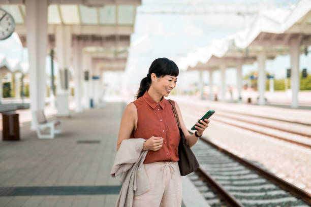 istock Woman waiting for a train on railway station. 2182409090