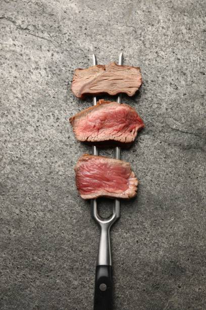 istock Delicious sliced beef tenderloin with different degrees of doneness on grey table, top view 2182409357