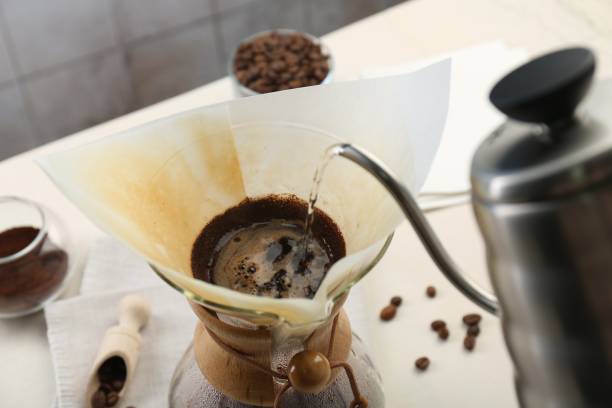 istock Making drip coffee. Pouring hot water into chemex coffeemaker with paper filter at table, closeup 2182410063