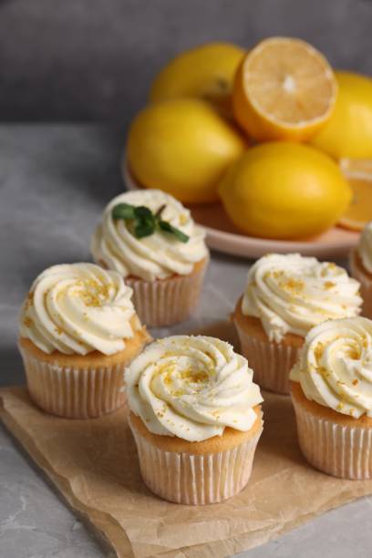 istock Delicious cupcakes with white cream and lemon zest on table, closeup 2182410914