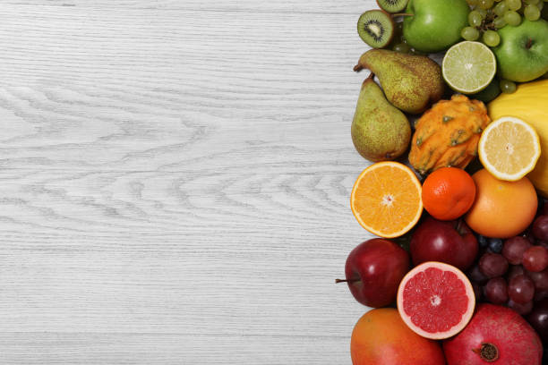 istock Many different fresh fruits on light wooden table, flat lay. Space for text 2182411113