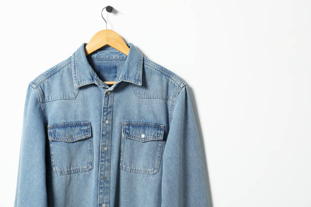 istock Hanger with denim shirt on white wall, space for text 2182414849