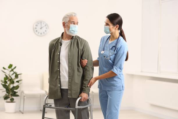 istock Young nurse supporting elderly patient in hospital 2182418755
