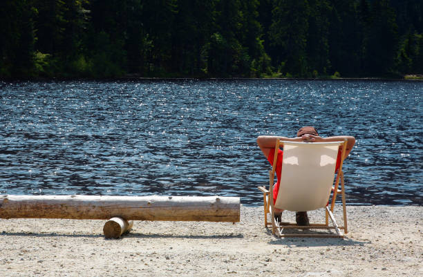 Man sitting in the beach chair, Hintersee, Bavaria, Germany.