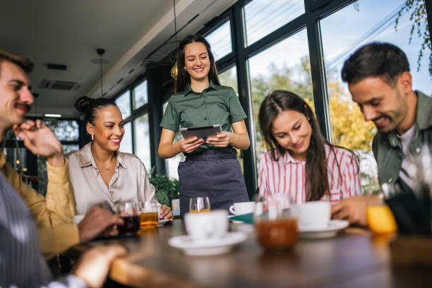 istock Group of people ordering food from the waitress. Waitress writing orders down on tablet. 2182421096