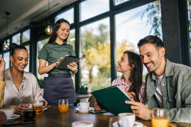 istock Group of people ordering food from the waitress. Waitress writing orders down on tablet. 2182421097