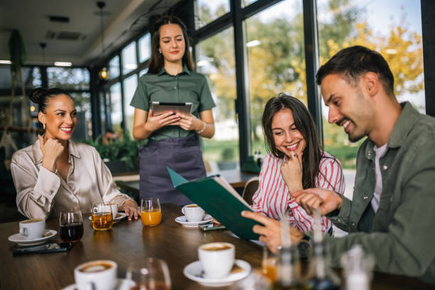 istock Group of people ordering food from the waitress. Waitress writing orders down on tablet. 2182421098