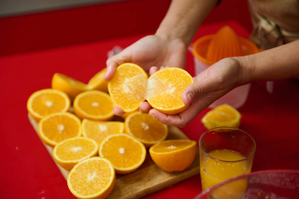 istock Fresh oranges being cut and prepared for making juice 2182426462