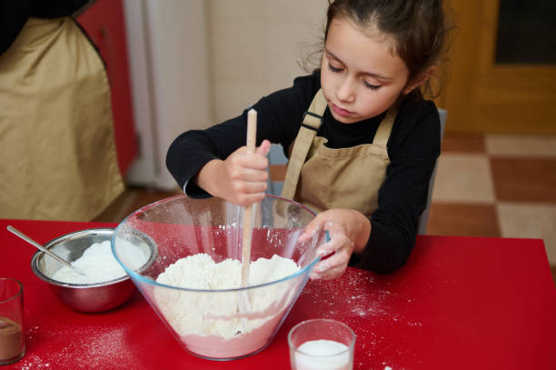istock Young girl engaged in baking activity in the kitchen 2182426851