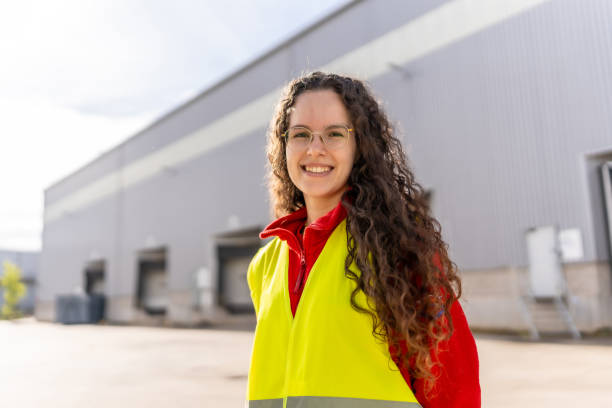 istock Young female employee standing outside a distribution warehouse 2182429576