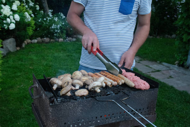 istock Man cooking food on grill outside. 2182430731
