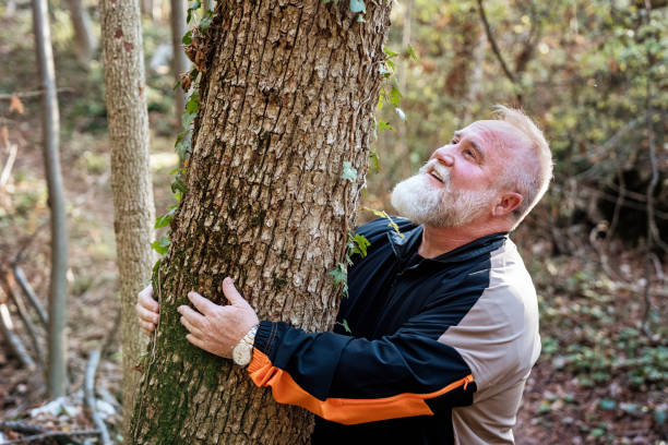 istock Mature man hugging a tree in the forest and finding peace. Forest bathing and meditation 2182430757