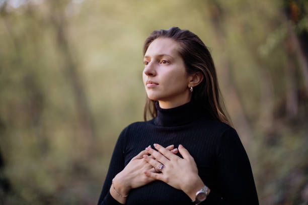 Young woman breathing fresh air and connecting with nature in the forest