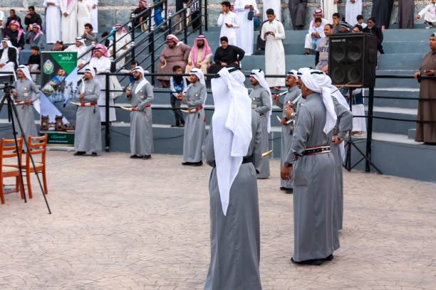 Arab businessmen wearing saudi kandura meeting in office for business deal - Corporate business group of middle-eastern people working in an international company in middle east