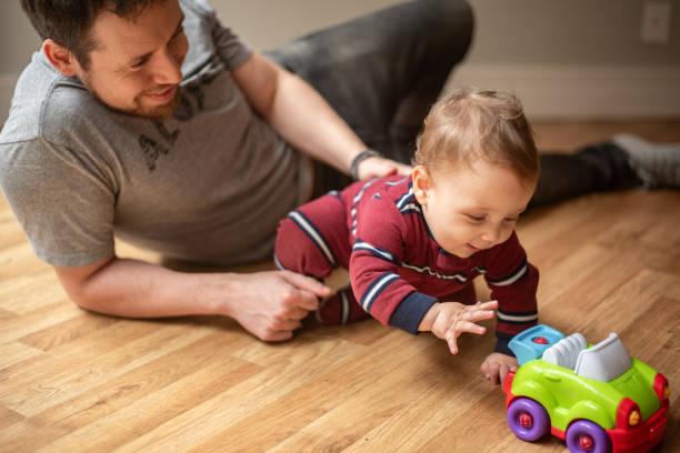 istock Baby plays with toy car with his dad 2182442835