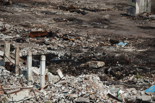 A close-up view of rubble and debris scattered across an abandoned demolition site. Broken concrete, twisted metal, and remnants of structure indicate the aftermath of industrial dismantling.