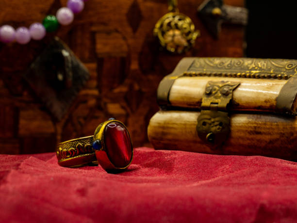 istock reproduction golden ring with ruby gem decorated medieval with an ivory casket on a red velvet table 2182447110