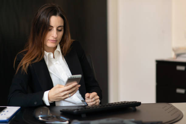 istock Businesswoman using smartphone at office desk 2182447732
